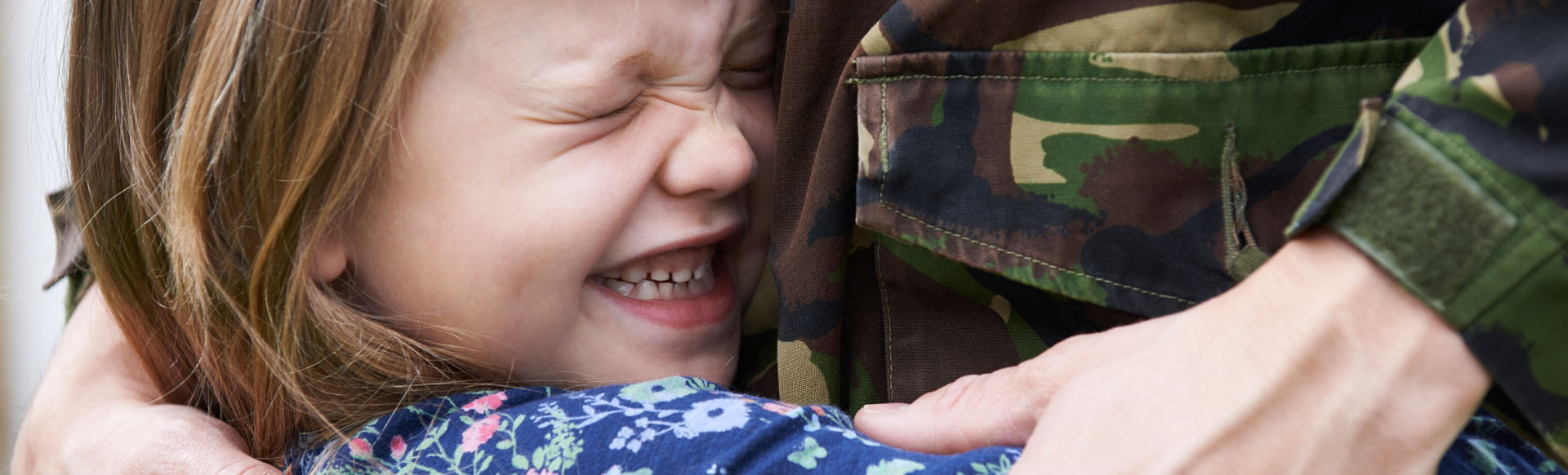 Image showing a close up of a young girl hugging her Dad in army uniform