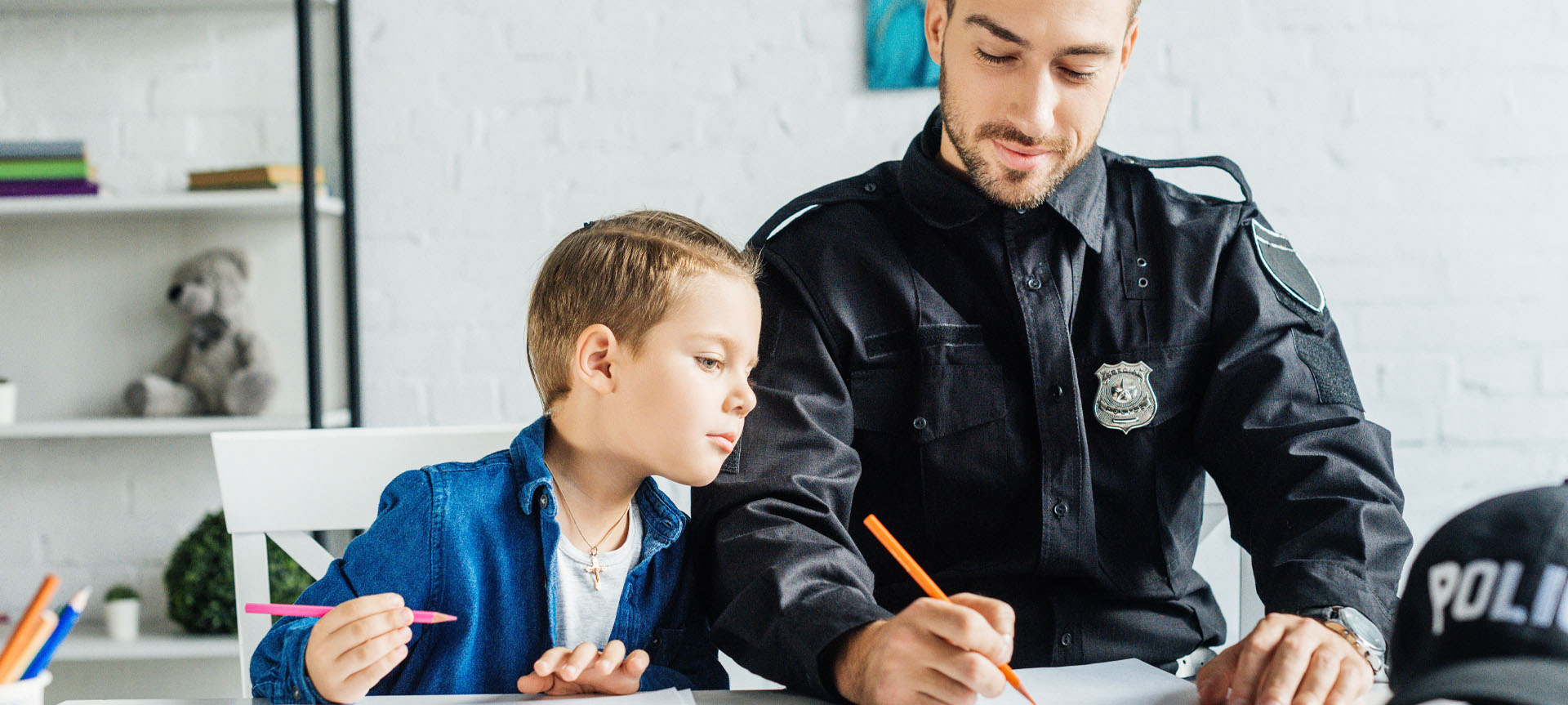 Image showing a police officer drawing with his son at home