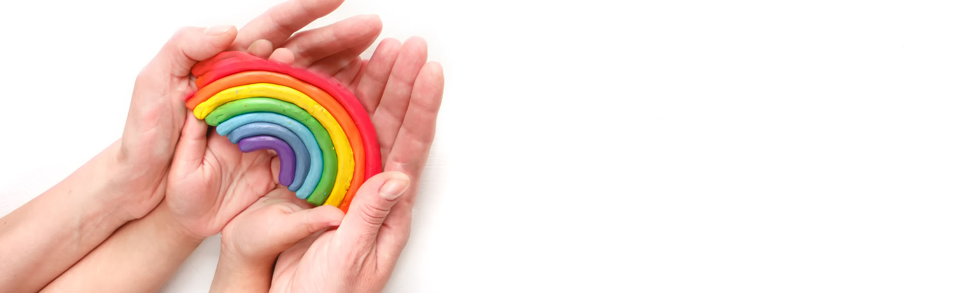 Image showing a close up of an adult and a child holding a rainbow in their hands