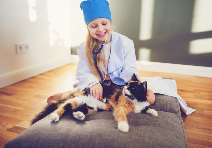Image showing a girl dressed as a doctor using a stethescope on her cat