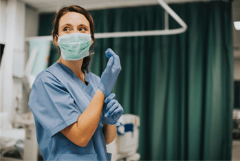 Female nurse with a mask putting on gloves