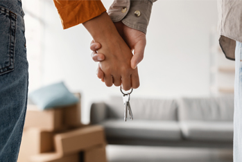 image showing a  couple holding hands and keys of a home