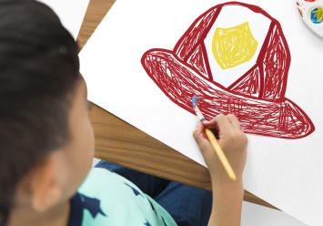 Image showing a boy painting a fireman's helmet