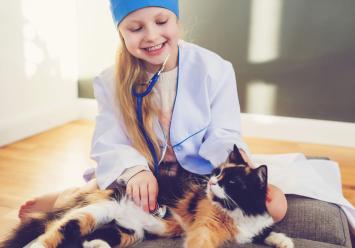 Image showing a girl dressed as a doctor using a stethescope on her cat